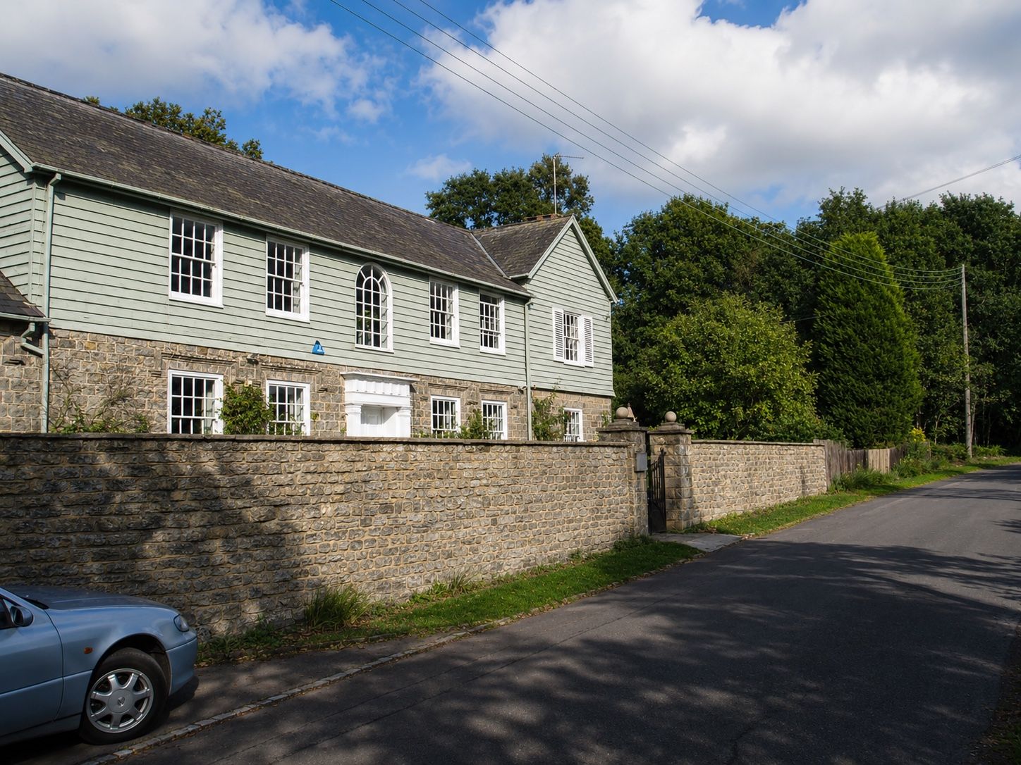 Finished timber-clad and stone house viewed from the road