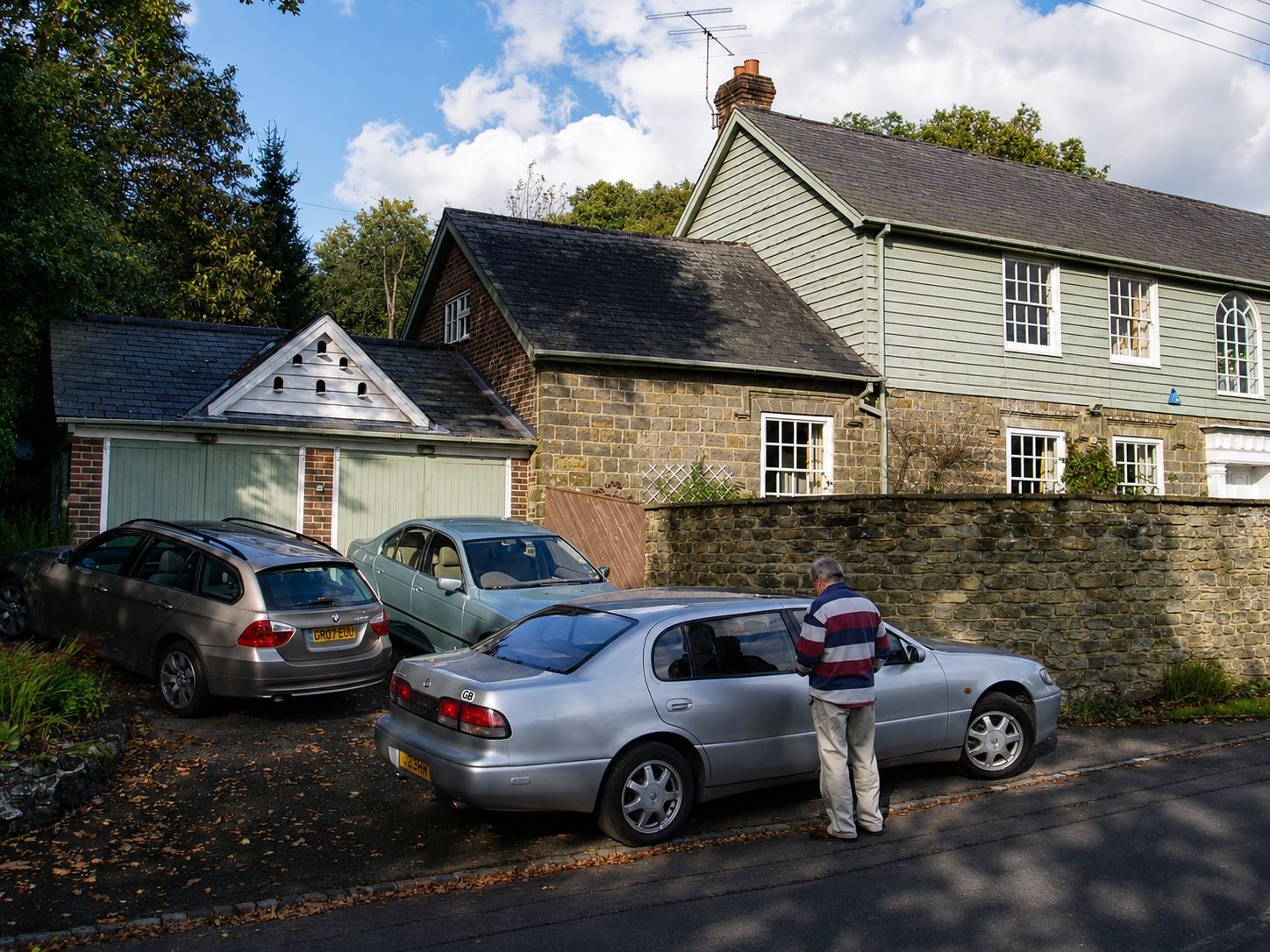 Side elevation of a timber-clad and stone house with adjoining garage